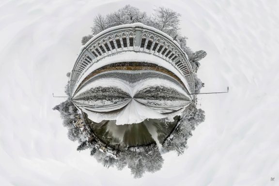 Vue panoramique d'un paysage enneigé avec un édifice au premier plan.